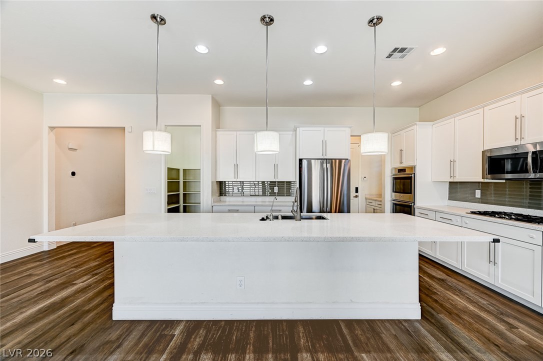 8197 Riley Love Street Las Vegas, NV 89139 - Photo 15 of 48 An inviting kitchen with a spacious island, pendant lighting, and modern stainless steel appliances.