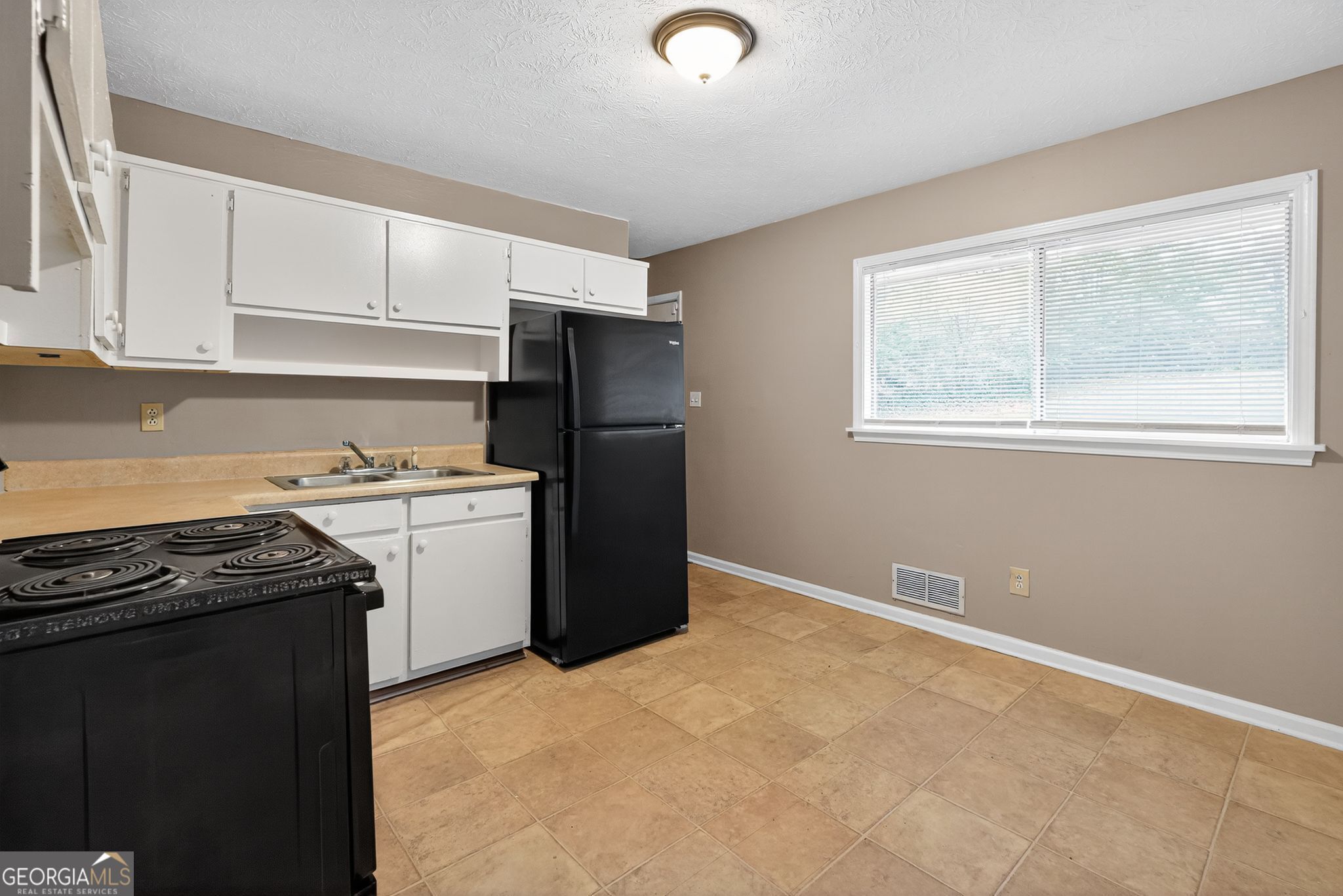 8207 Dunellen Lane Jonesboro, GA 30238 - Photo 14 of 33 a kitchen with a refrigerator stove and cabinets