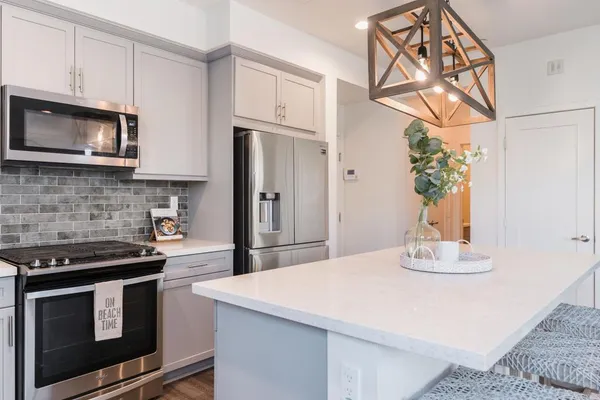 a kitchen with stainless steel appliances granite countertop a stove a microwave and a refrigerator