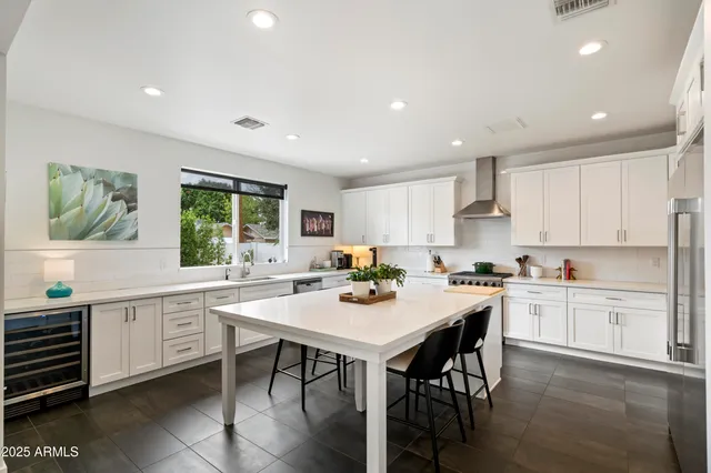a kitchen with a stove a sink a dining table and chairs