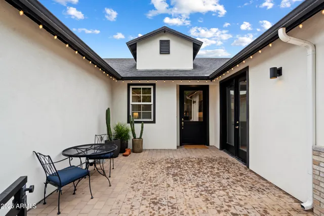 a view of a backyard with table and chairs and wooden fence