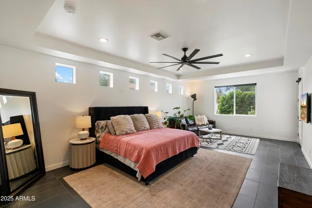 a bedroom with a bed a window and a chandelier