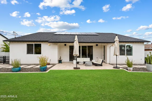 a view of a house with a backyard and sitting area