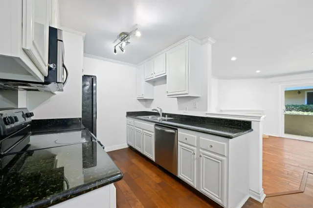 a kitchen with stainless steel appliances granite countertop a sink and a stove