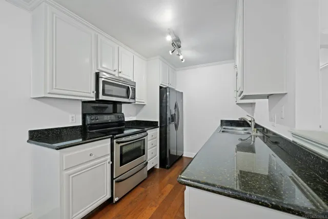 a kitchen with stainless steel appliances granite countertop a sink and a stove