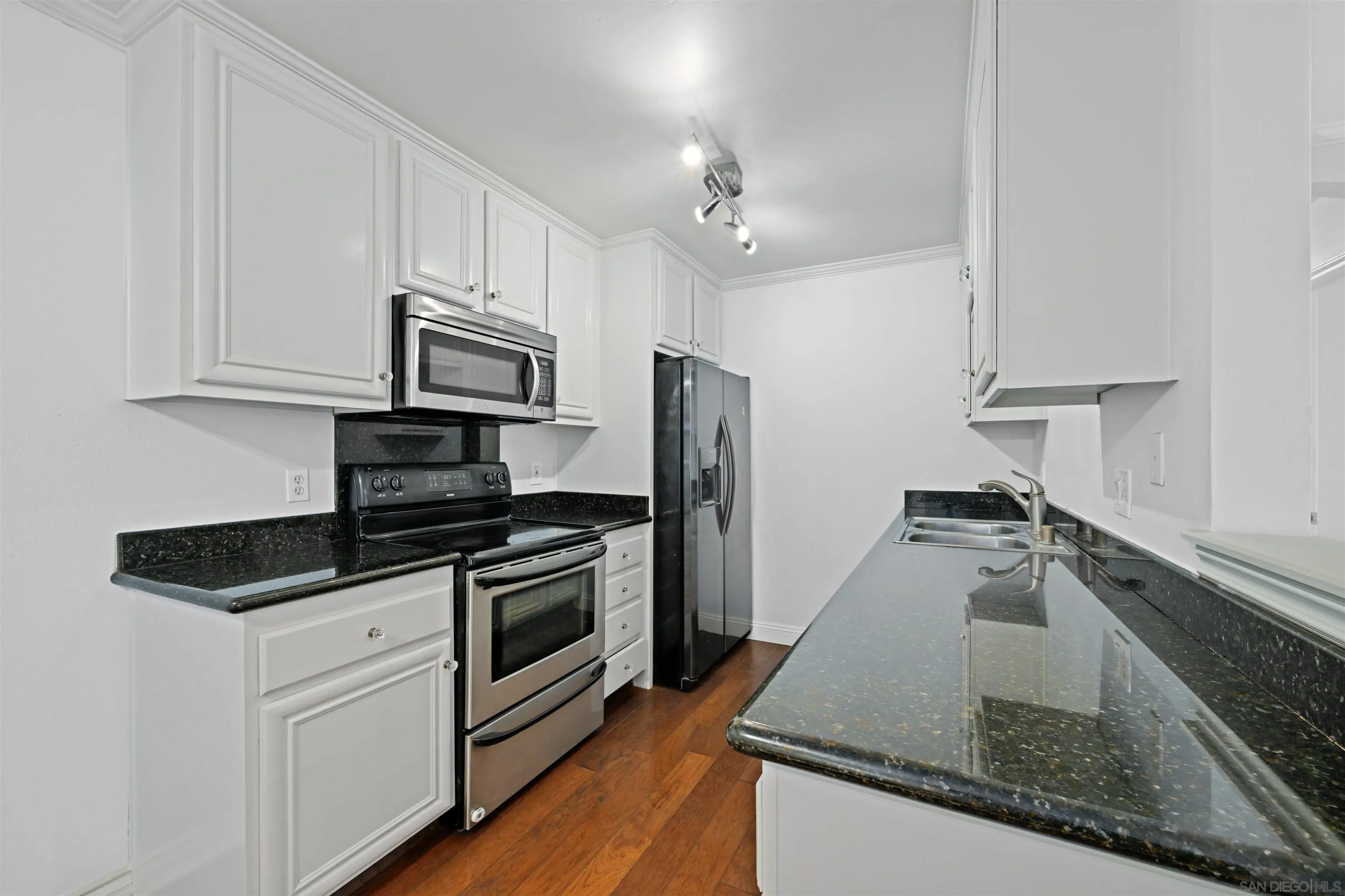 9939 Erma Road, Unit 101 San Diego, CA 92131 - Photo 8 of 24 a kitchen with stainless steel appliances granite countertop a sink and a stove