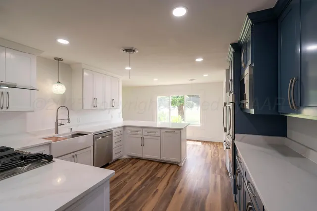 a kitchen with sink cabinets and wooden floor