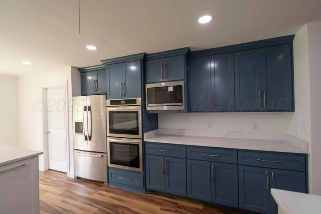 a kitchen with stainless steel appliances a refrigerator and wooden cabinets