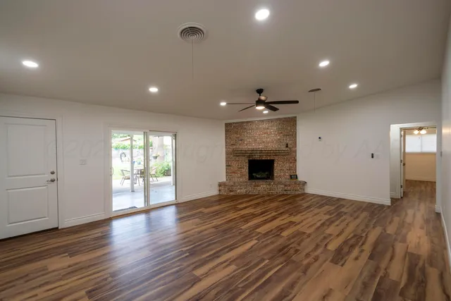 an empty room with wooden floor and fireplace