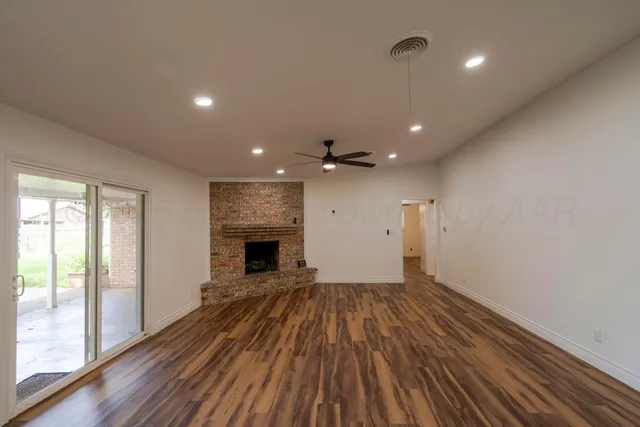 a view of empty room with wooden floor and fireplace