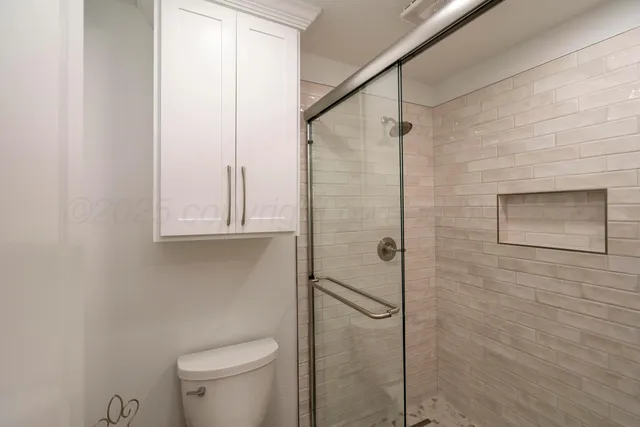 a bathroom with a toilet and a shower