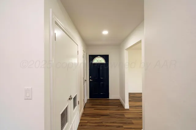 a view of a hallway with wooden floor and staircase