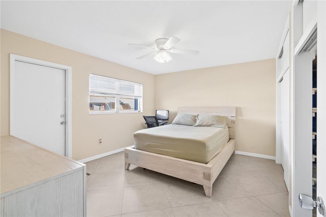 3801 Northeast 22nd Terrace, Unit 12A Lighthouse Point, FL 33064 - Photo 14 of 34 a spacious bedroom with a bed and a chandelier