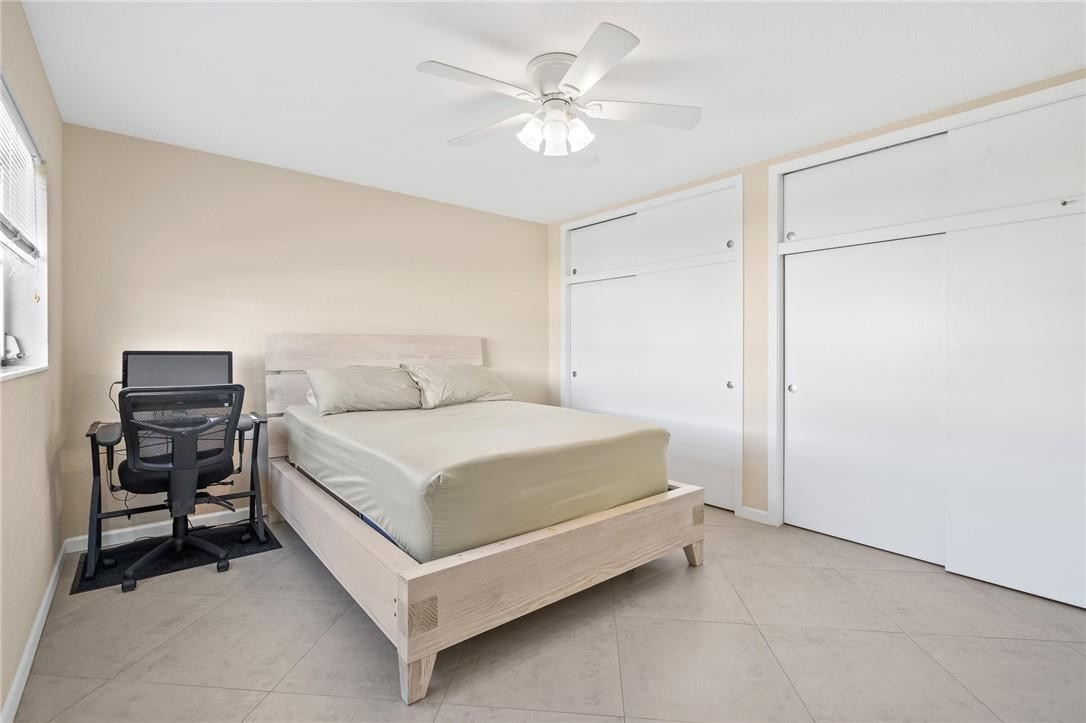 3801 Northeast 22nd Terrace, Unit 12A Lighthouse Point, FL 33064 - Photo 15 of 34 a bedroom with a bed and a chandelier
