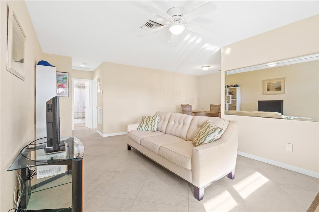 3801 Northeast 22nd Terrace, Unit 12A Lighthouse Point, FL 33064 - Photo 5 of 34 a living room with furniture and a flat screen tv