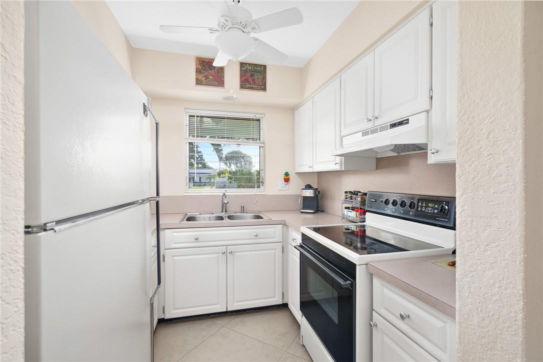 3801 Northeast 22nd Terrace, Unit 12A Lighthouse Point, FL 33064 - Photo 9 of 34 a kitchen with cabinets appliances a sink and a window