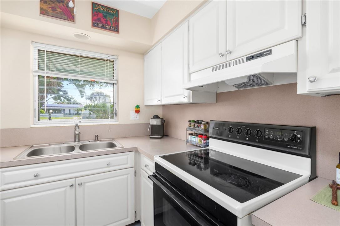 3801 Northeast 22nd Terrace, Unit 12A Lighthouse Point, FL 33064 - Photo 10 of 34 a kitchen with granite countertop a stove sink and cabinets