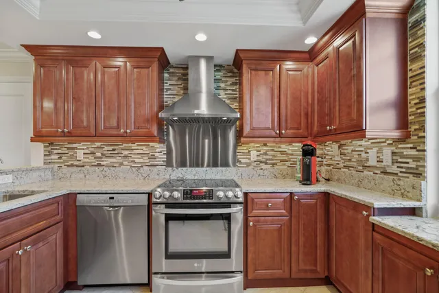 a kitchen with stainless steel appliances granite countertop wooden cabinets stove top oven and sink
