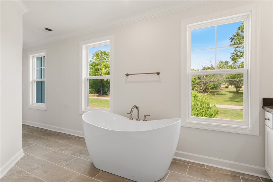 1108 Manse Jolly Road Anderson, SC 29621 - Photo 27 of 45 This bright bathroom features an elegant soaking tub and large windows overlooking lush greenery.