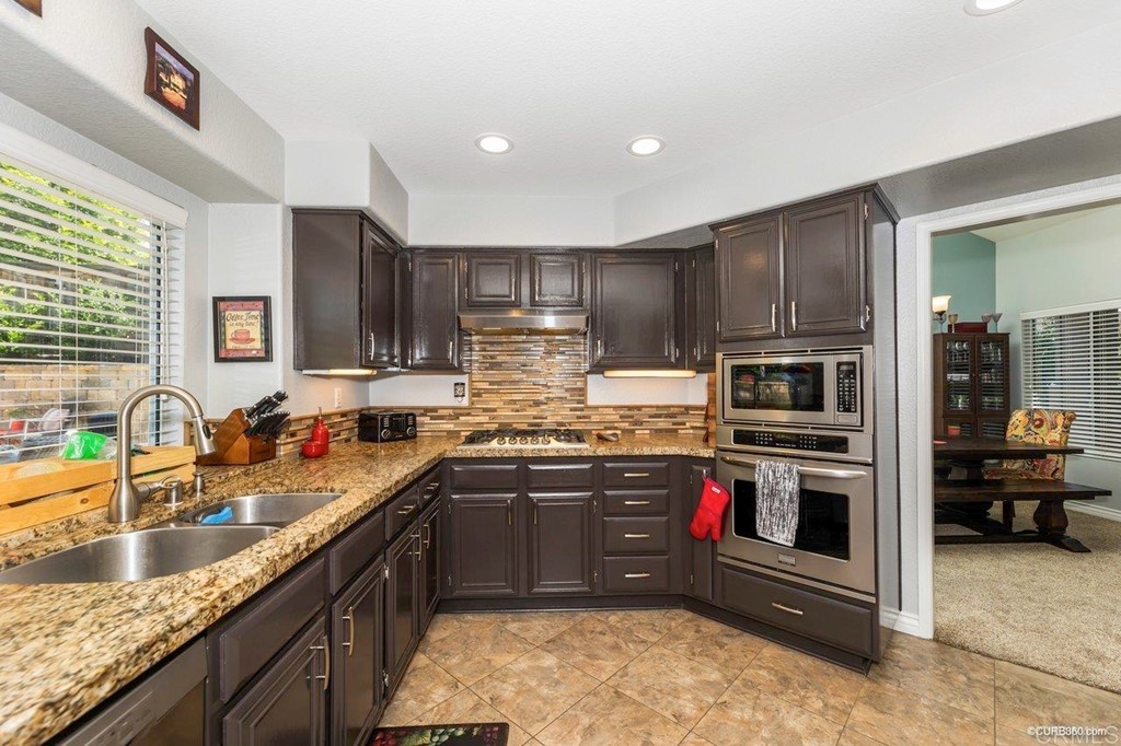 1840 Century Way Escondido, CA 92026 - Photo 15 of 36 a kitchen with stainless steel appliances granite countertop a sink stove and refrigerator