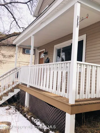 a view of a house with wooden deck and furniture