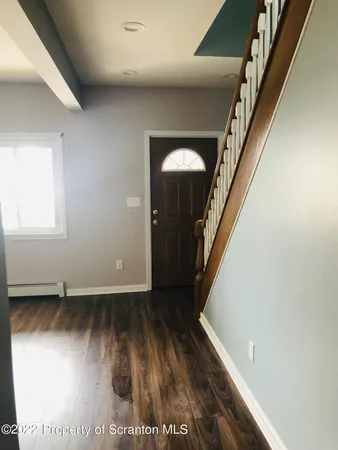 a view of a hallway with wooden floor and stairs