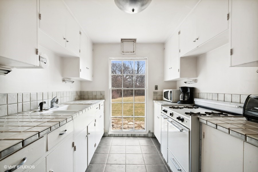 401 Lee Road Northbrook, IL 60062 - Photo 7 of 15 a kitchen with granite countertop a sink stove and cabinets