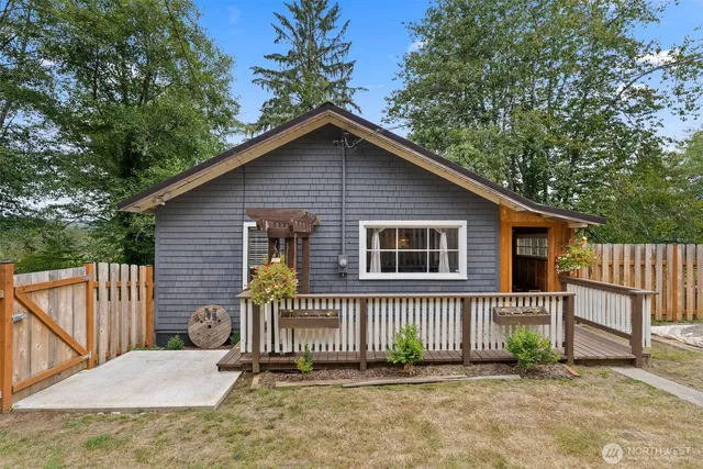 a view of a house with a small yard and wooden fence