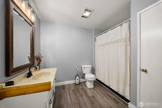 a bathroom with a sink a toilet and a mirror