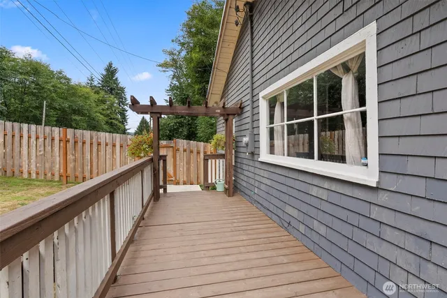 a view of a balcony with wooden floor and floor to ceiling window and wooden fence