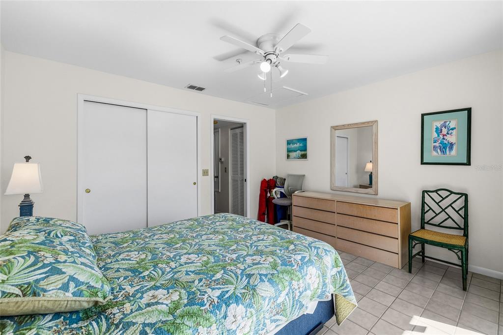 9400 Little Gasparilla, Unit F7 Placida, FL 33946 - Photo 12 of 39 a bedroom with a bed and a chandelier
