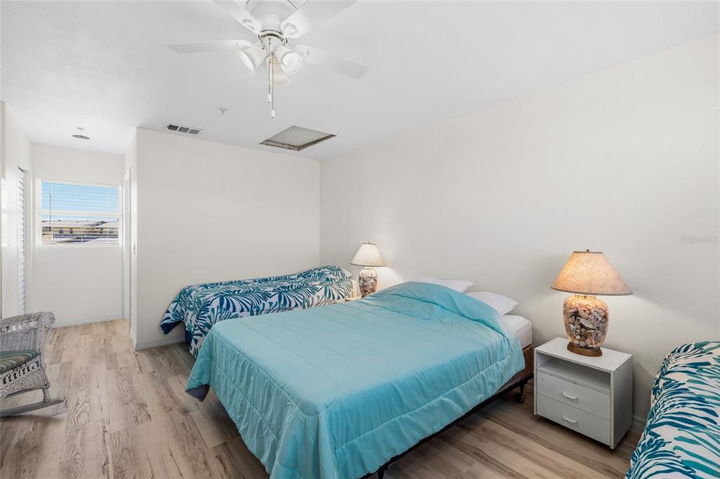 9400 Little Gasparilla, Unit F7 Placida, FL 33946 - Photo 18 of 39 a bedroom with a bed and wooden floor