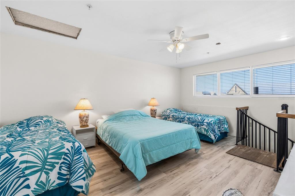 9400 Little Gasparilla, Unit F7 Placida, FL 33946 - Photo 21 of 39 a bedroom with two beds and a chandelier