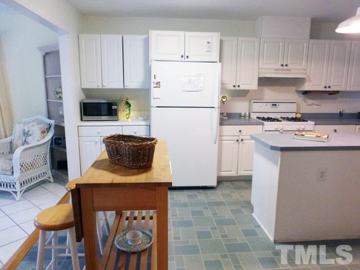 4807 Sinclair Drive Raleigh, NC 27616 - Photo 6 of 25 a kitchen with stainless steel appliances granite countertop a stove a refrigerator a sink a stove and white cabinets