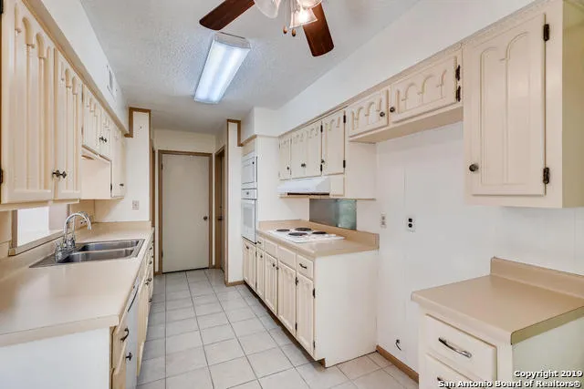 a kitchen with a stove a sink and a refrigerator