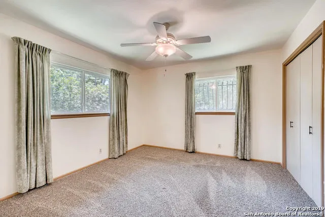 an empty room with windows and closet