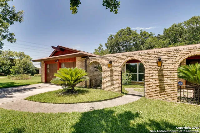 a view of a white house with a yard and plants