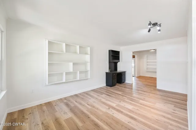 a view of a room with wooden floor and windows