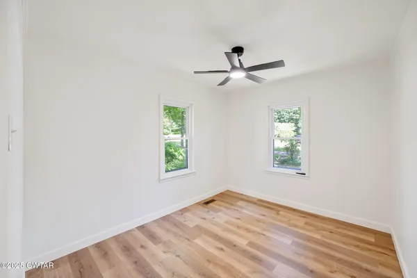a bathroom with a granite countertop sink a toilet and a window