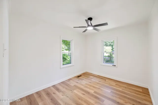 a bathroom with a granite countertop sink a toilet and a window