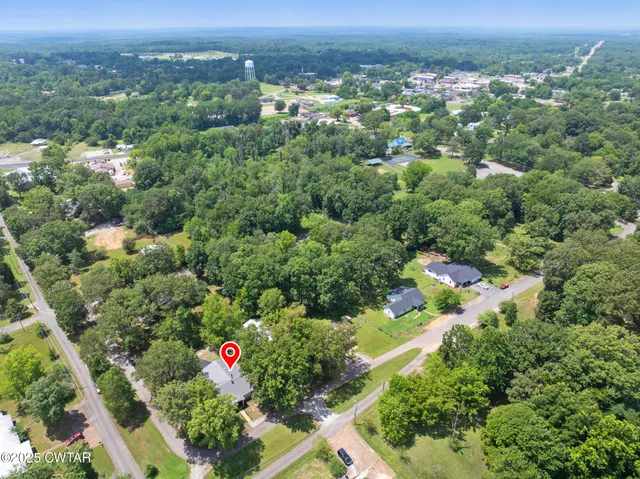 a view of a yard in front of a house with a large tree