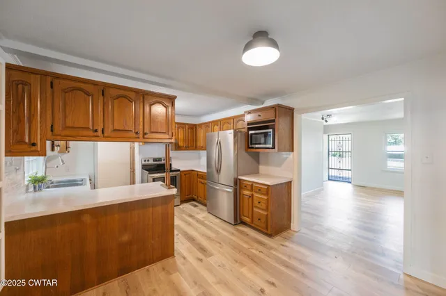 a view of a kitchen with wooden cabinet and staircase