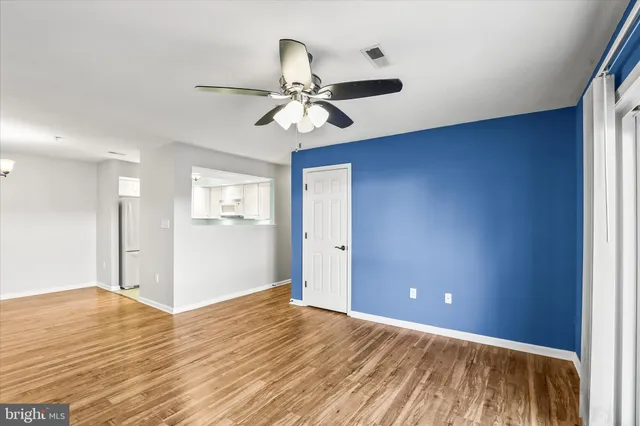 a view of an empty room and window and wooden floor