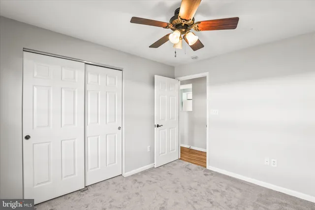 an empty room with closet and a chandelier fan