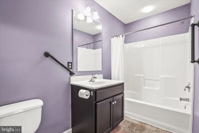 a bathroom with a sink a toilet a mirror and shower