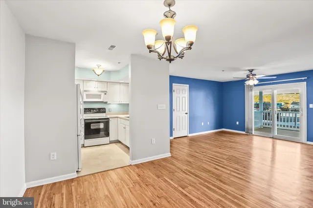 a view of a kitchen with a stove wooden cabinets and wooden floor
