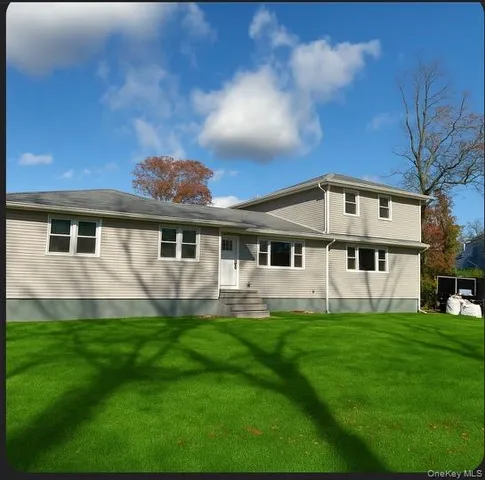a front view of a house with a yard and trees