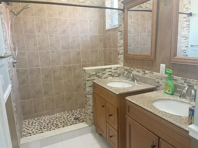 a bathroom with a sink shower and a mirror