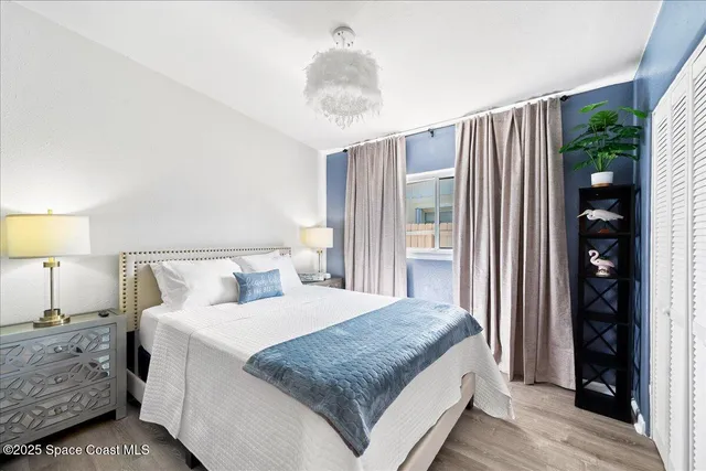 a bedroom with a large bed and a chandelier