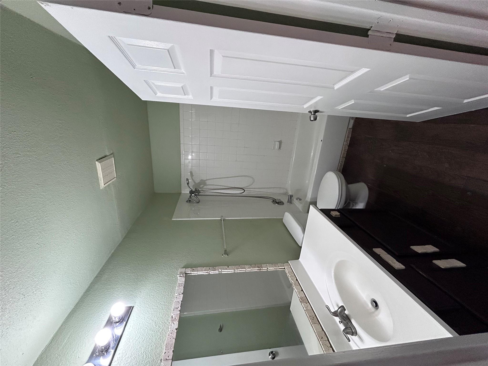 5708 Spring Meadow Road, Unit B Austin, TX 78744 - Photo 13 of 23 Full bath featuring vanity, a textured ceiling, shower / washtub combination, dark wood-style flooring, and a textured wall
